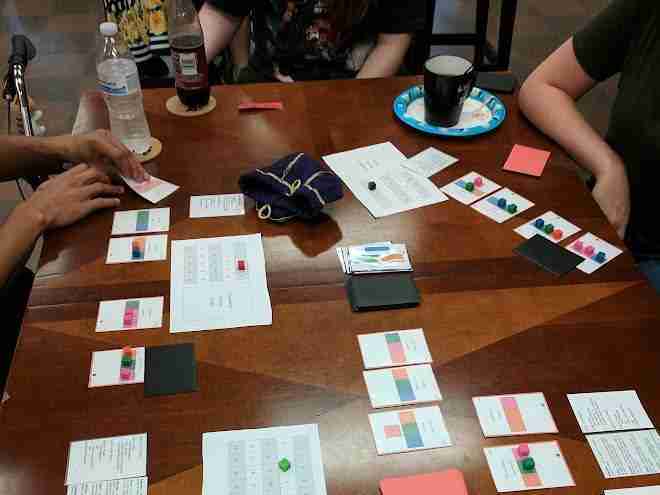 Playtesters around a table with a prototype game.