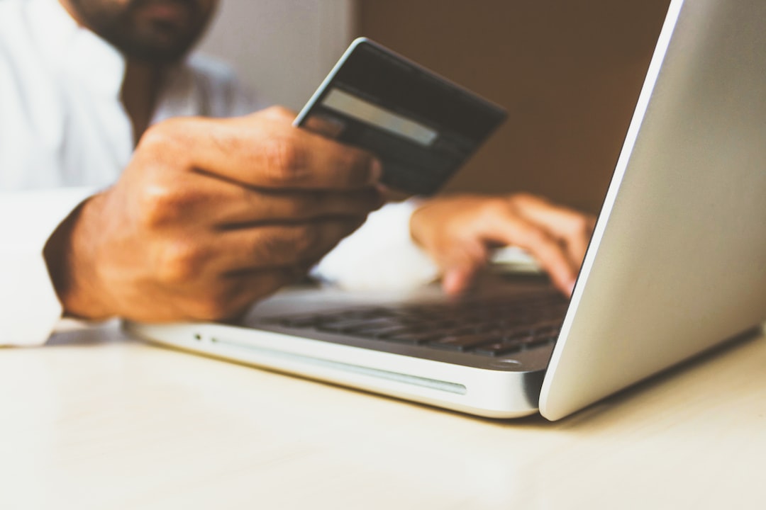 person using online-ordering-system on a laptop computer holding card