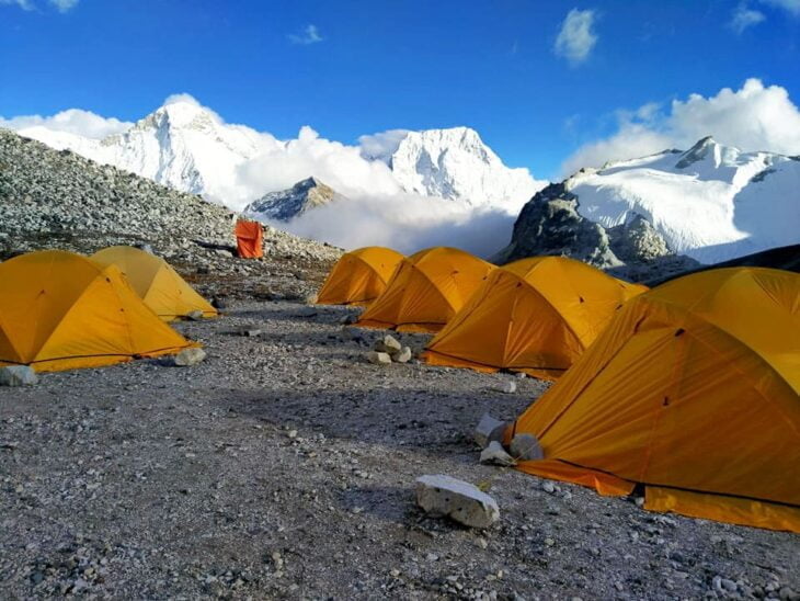 A view of colorful tents at Mera Peak Base Camp, set against the backdrop of the Khumbu region's towering peaks. The temporary shelters provide a cozy and lively atmosphere for climbers at 6,476 meters elevation.