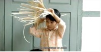 A child holding a straw hat Description automatically generated