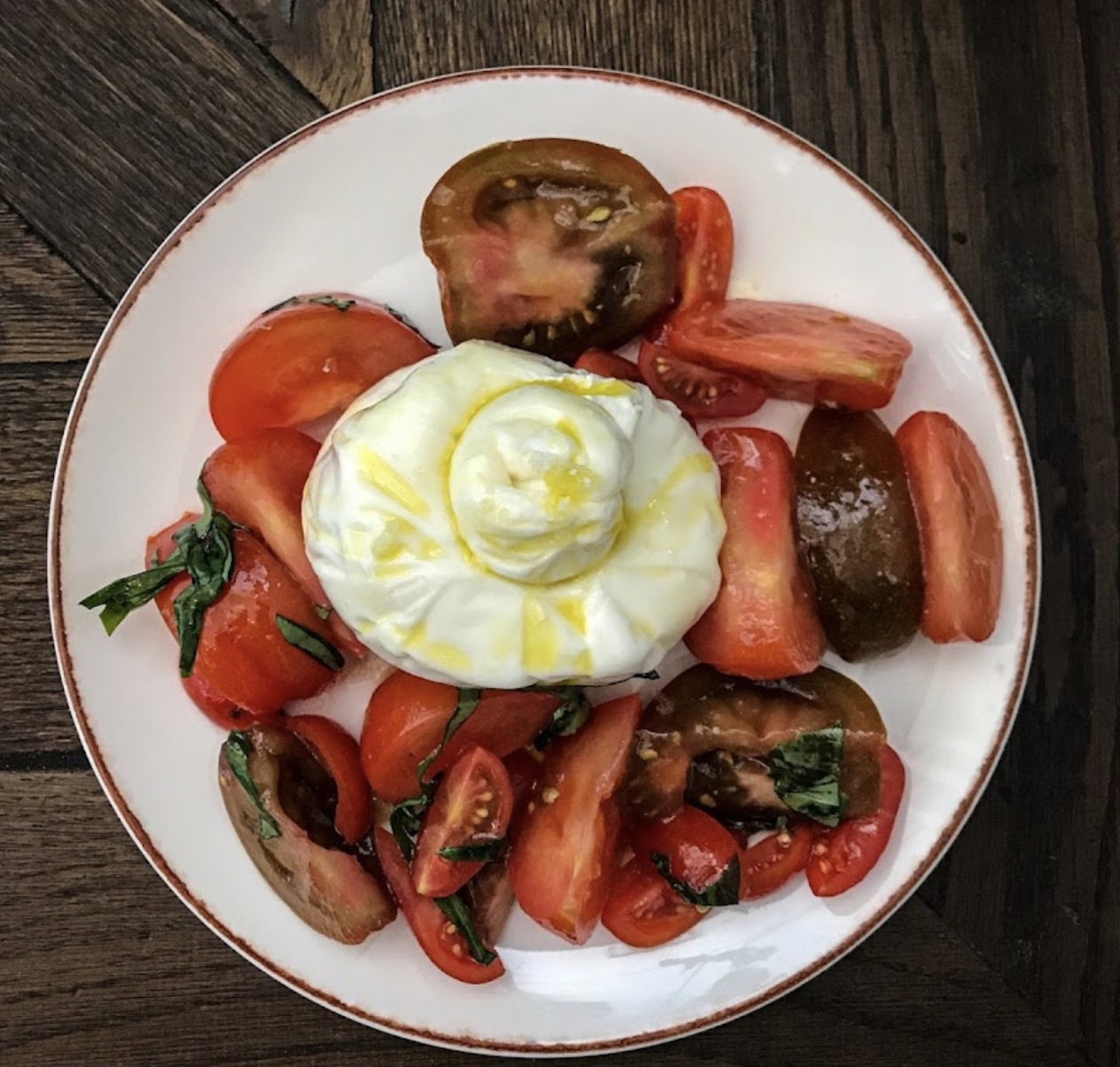 tomatoes and cheese with olive oil and basil sprinkled on top