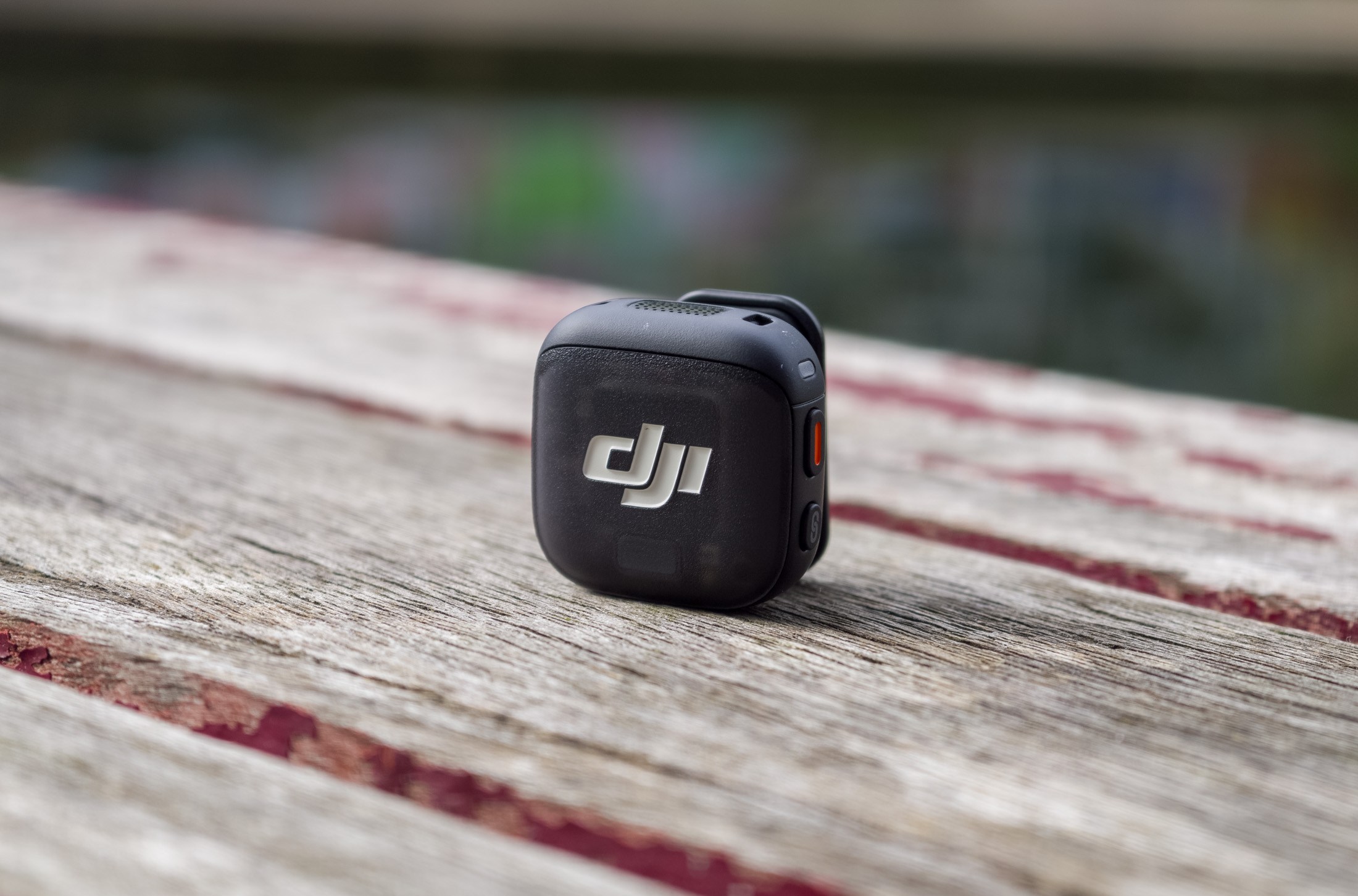 Photo of DJI Mic 3 on a wooden table in front of a canal