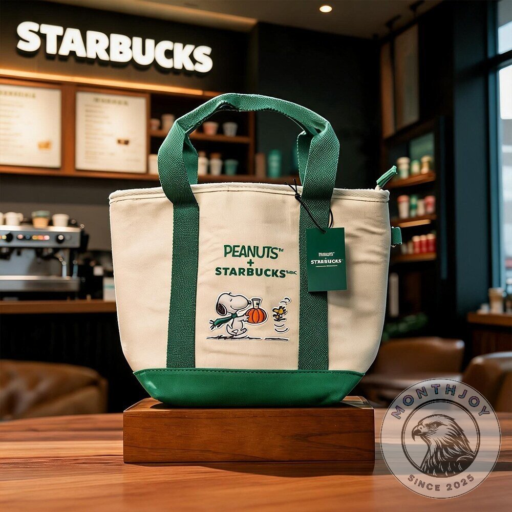 Snoopy Starbucks Peanuts Pumpkin Graphic Canvas Tote Bag - front view with green handles and character artwork