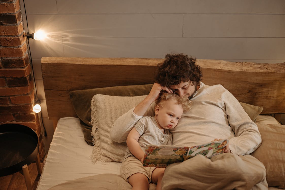 cozy parent reading bedtime story to child warm bedroom