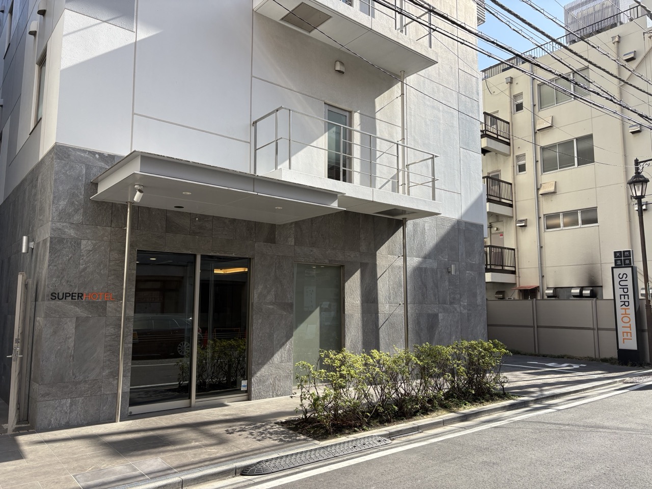 道の左側にスーパーホテルとトゥクトゥクがあります