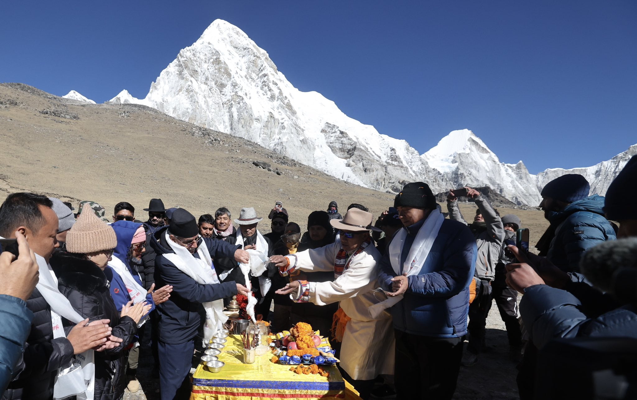 Nepalese officials, including the Prime Minister, participate in a traditional ceremony with a mountainous backdrop at Kalapathar.