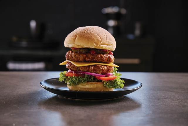 A large burger on a plate

AI-generated content may be incorrect.