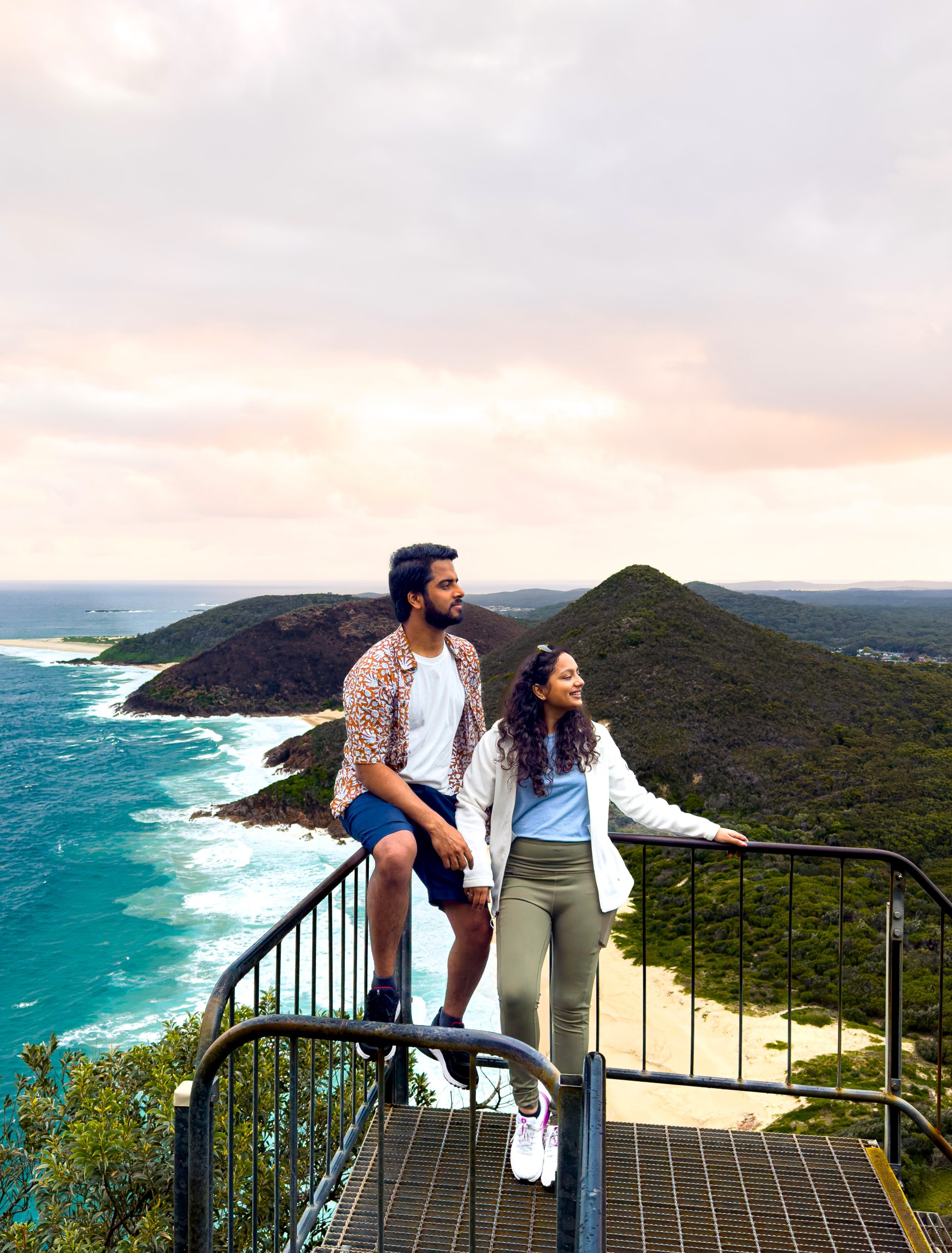 A couple enjoying the stunning coastal view from Tomaree Head lookout — one of the best things to do in Sydney in November for scenic hikes and nature lovers.