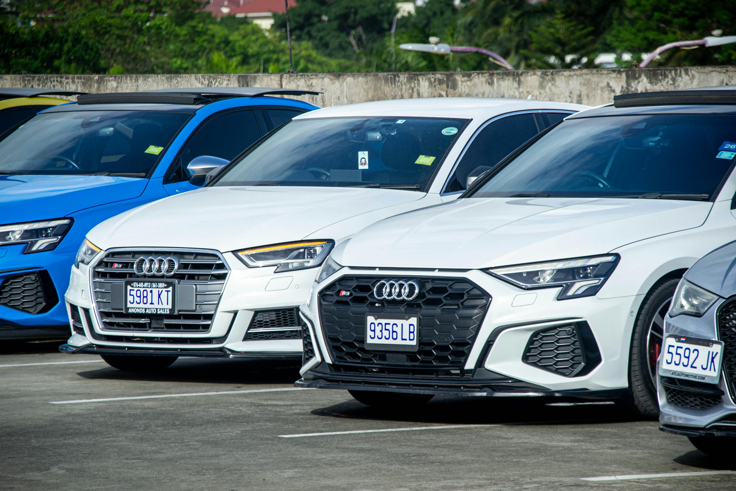 Audi cars lined up in a parking lot outdoors, showcasing modern design and style.