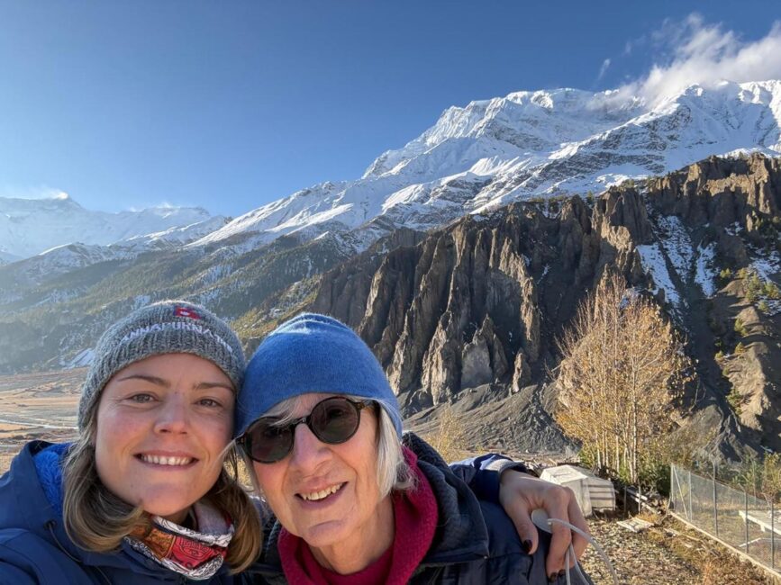 Two travellers posing on the Annapurna trek in winter with snow-covered mountains