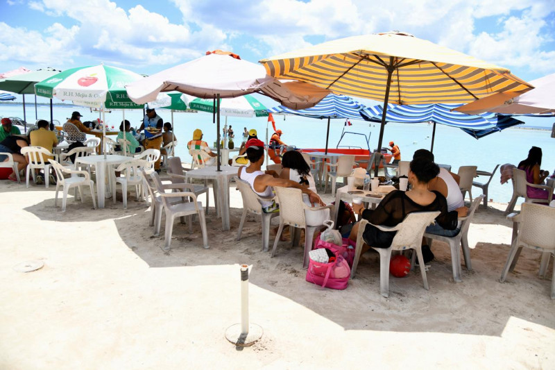 Various people sitting on the beach in Boca Chica.